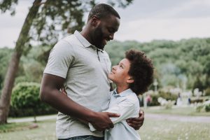 son and dad looking and hugging on each other
