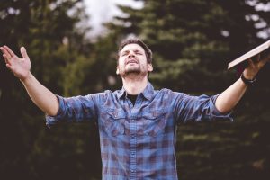 young male speaking and holding the bible in his hands